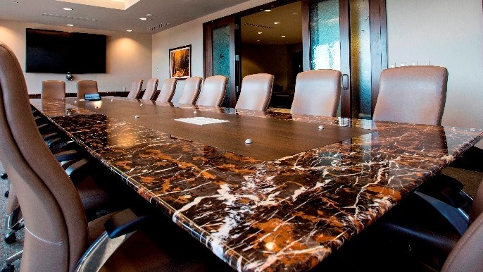 granite conference table with brown leather chairs